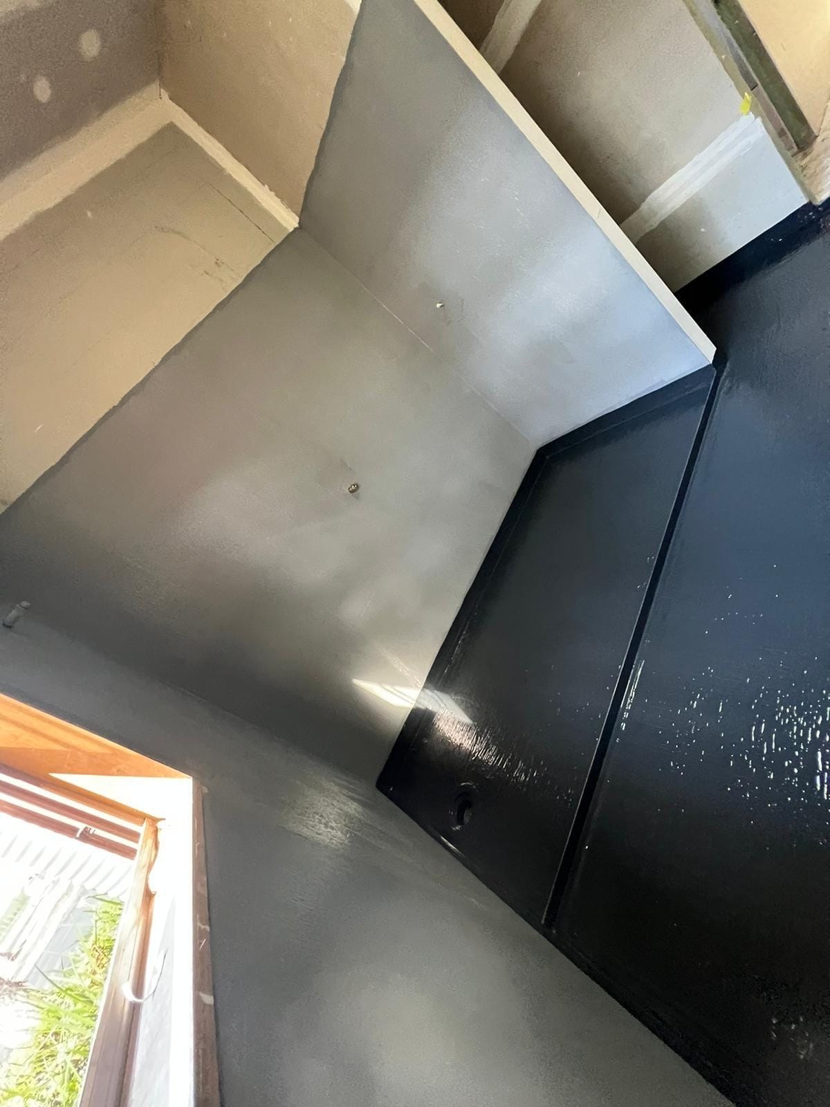 Waterproofing membrane taken over the shower hob and up the recess walls, corners reinforced and the outlet sealed before any tile goes down.