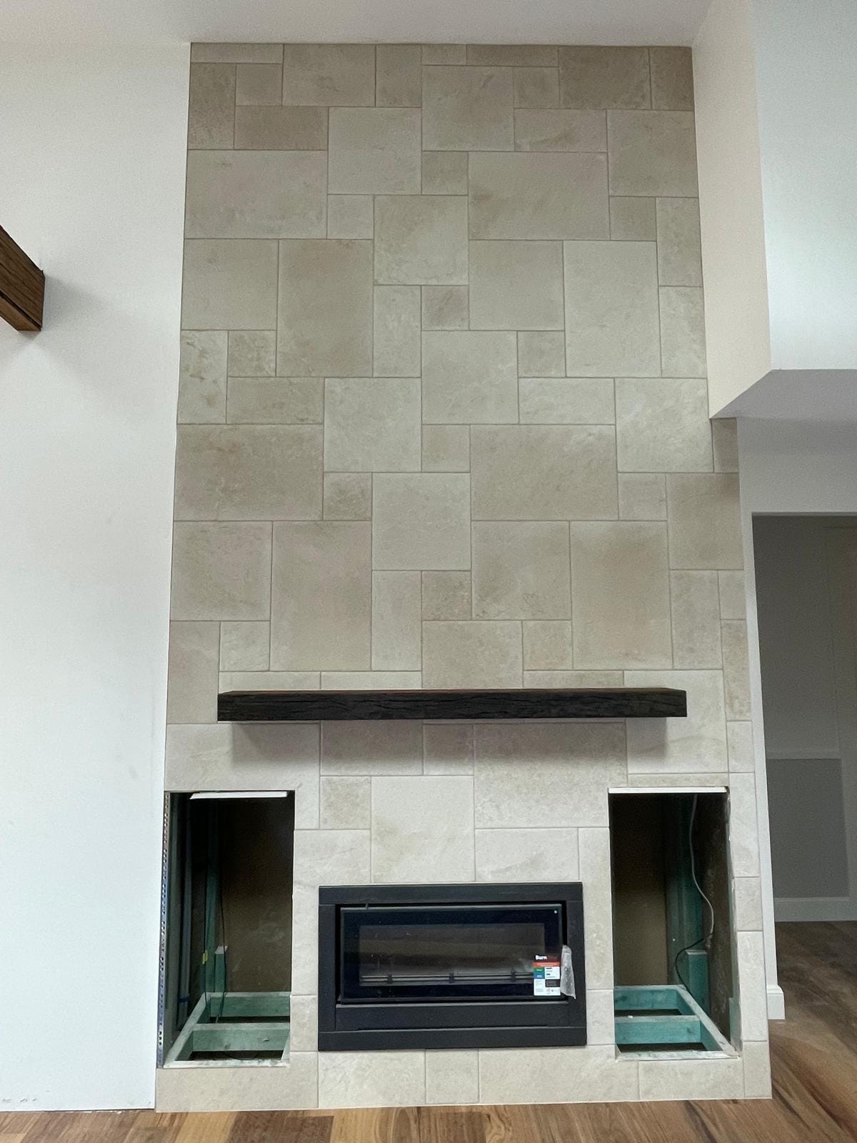A floor-to-ceiling limestone fireplace surround in a random ashlar pattern with a dark timber mantel